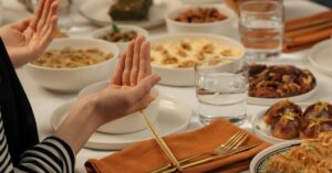 A family prays before enjoying a traditional Ramadan meal together at a beautifully set table.