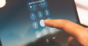 Close-up of a finger entering a passcode on a smartphone security screen.